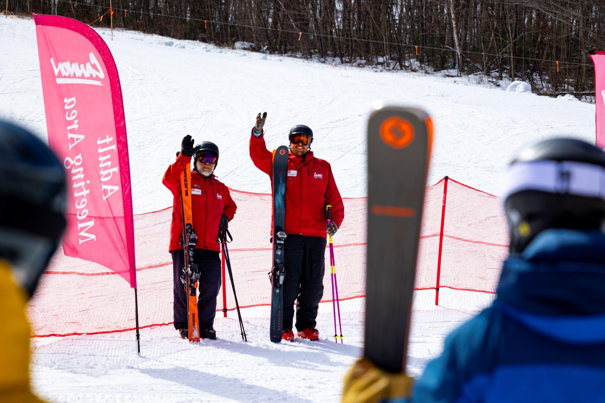 Snowsports instructors' wave to approaching students.