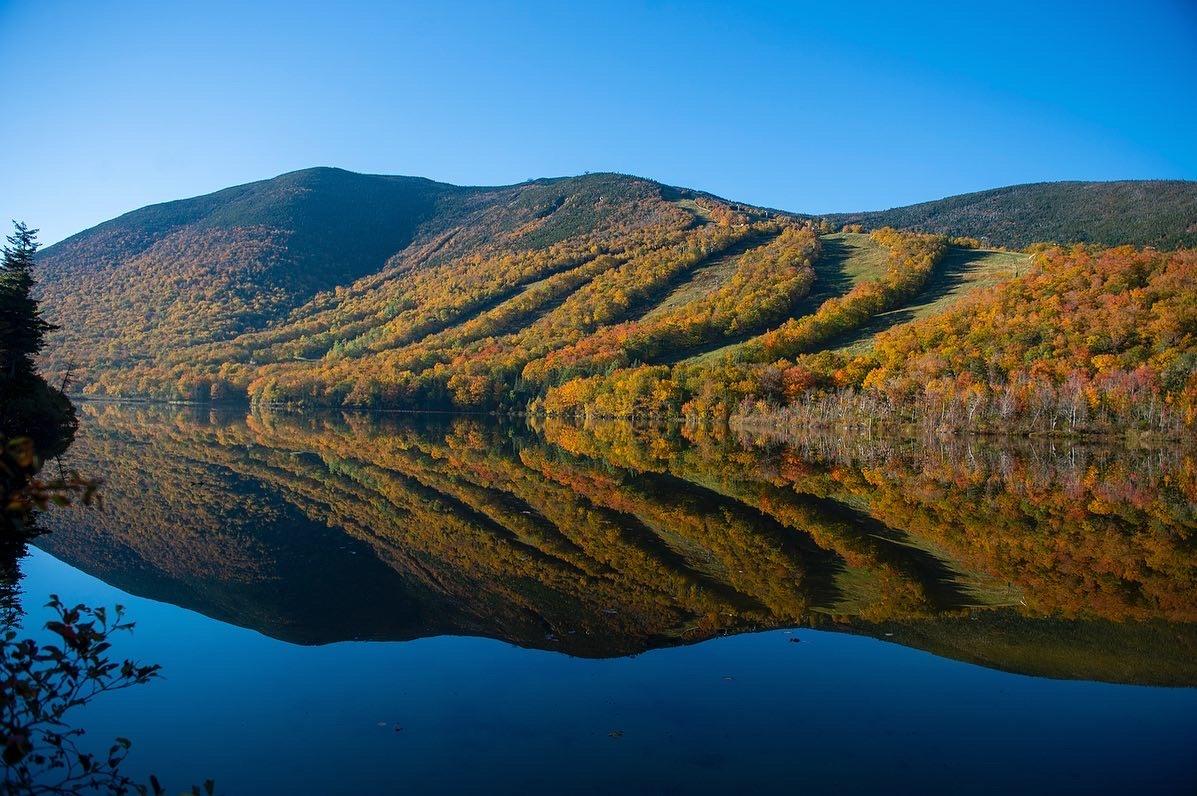 Cannon's Front5 with fall foliage reflected on a glassy Echo Lake.