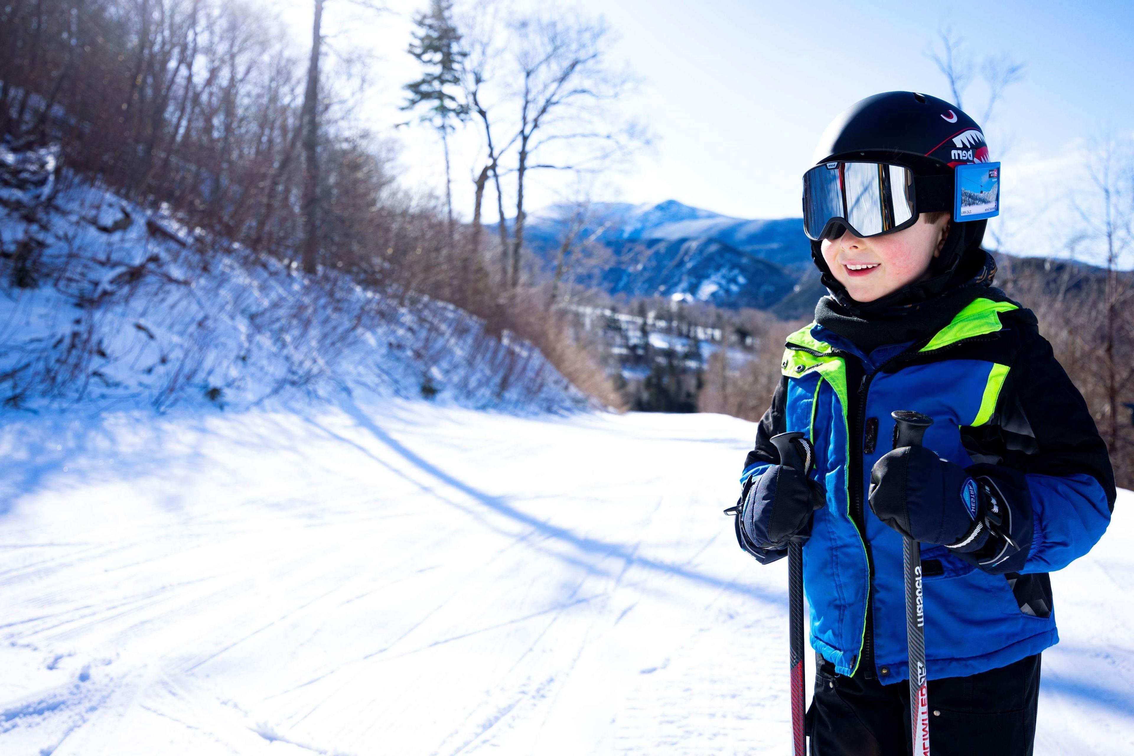 Child wearing blue ski jacket and mirrored goggles