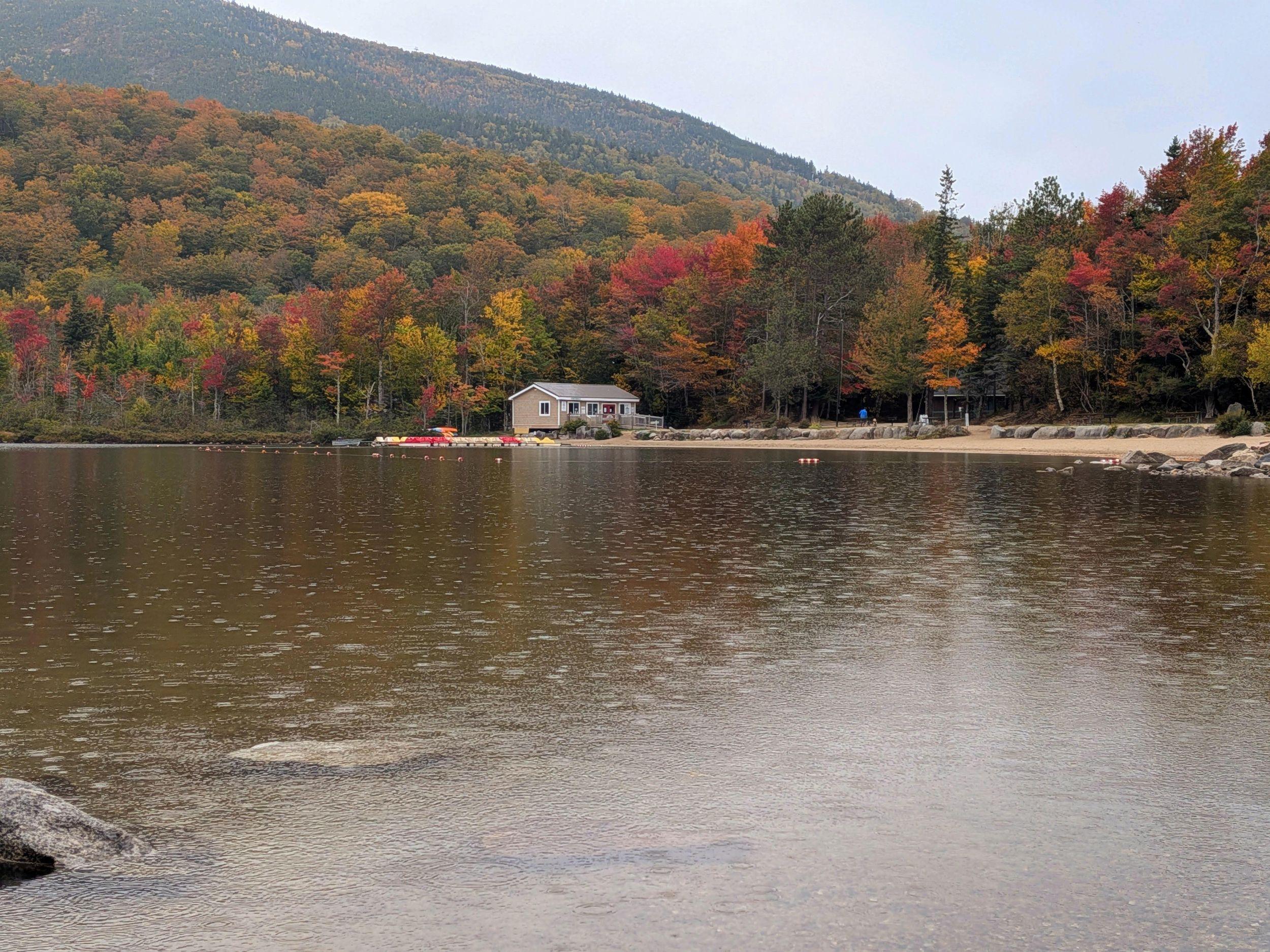 Echo Lack with raindrop ripples and fall trees surrounding the beach.